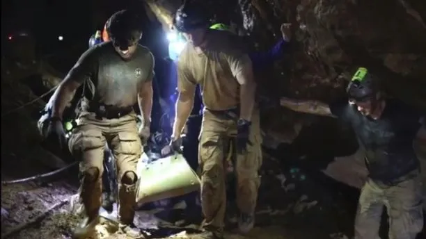 Một cậu bé được đưa lên cáng di chuyển qua đoạn không ngập nước trong hang động Tham Luang. Ảnh: THAI NAVY SEALS