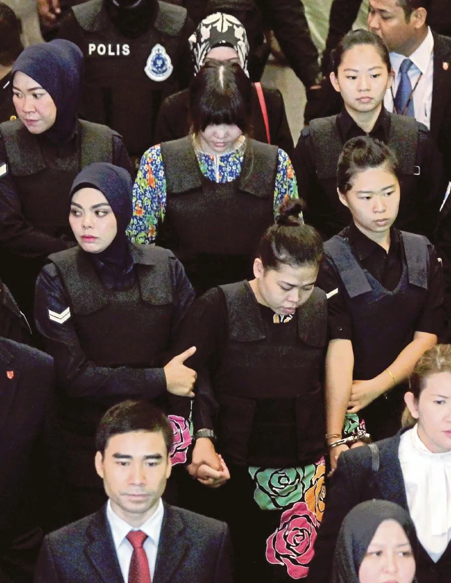 Các nghi can Siti Aisyah (giữa, hàng đầu) và Đoàn Thị Hương (giữa, hàng thứ hai) bị cảnh sát dẫn đến hiện trường vụ án ở sân bay quốc tế Kuala Lumpur (Malaysia) ngày 24-10-2017. Ảnh: NEW STRAIT TIMES