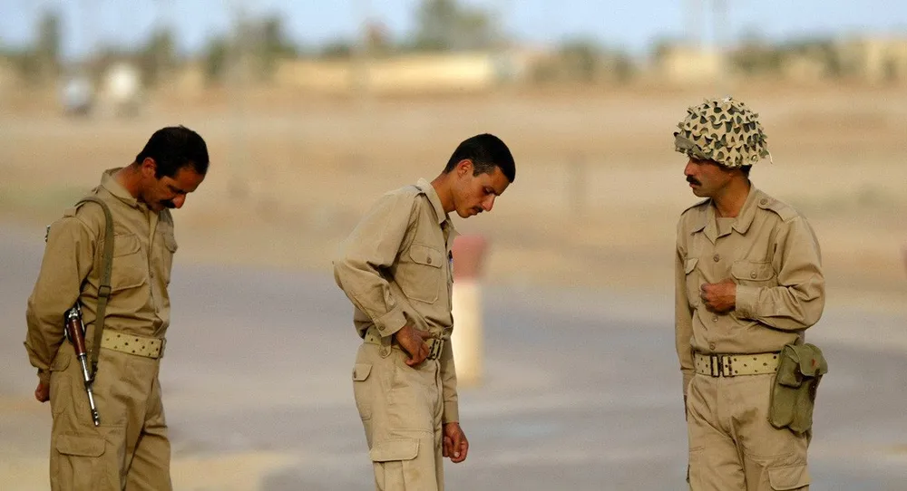 Các thành viên của nhóm đối lập Mujahideen-e Khalq đang trấn giữ một con đường dẫn tới trụ sở chính của nhóm tại TP Baqubah, thủ phủ Lãnh thổ Diyala (Iraq) tháng 5-2003. Ảnh: AP