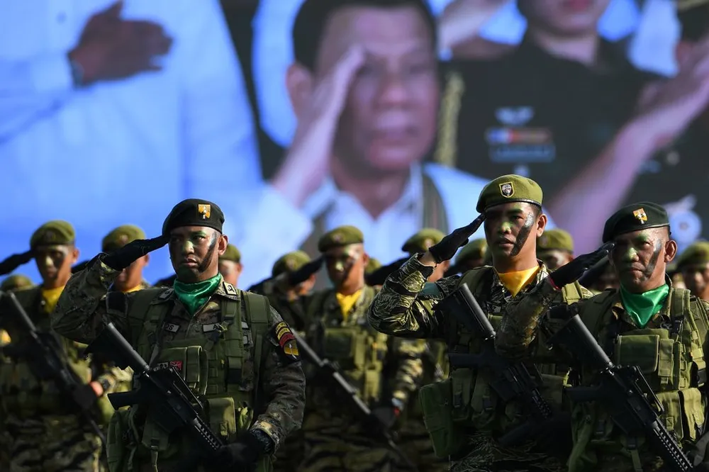 Quân đội Philippines trong một buổi lễ hồi tháng 3, với hình ảnh Tổng thống Rodrigo Duterte trên màn hình phía sau. Ảnh: GETTY IMAGES