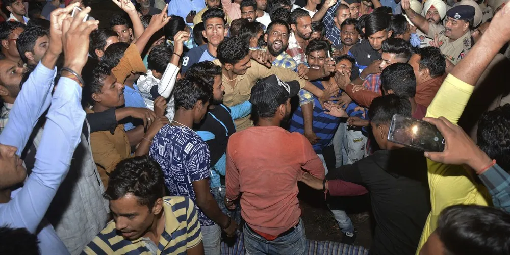 Đám đông giận dữ mang thi thể người bị tàu tông chết đến la hét tại một địa điểm quản lý đường ray ở ngoại ô TP Amritsar, bang Punjab (Ấn Độ). Ảnh: AP