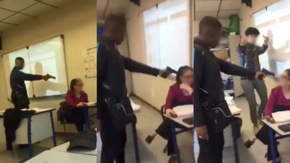 Ảnh cắt từ video cảnh học sinh đe dọa cô giáo ngay trong lớp bằng súng giả. Ảnh: AFP