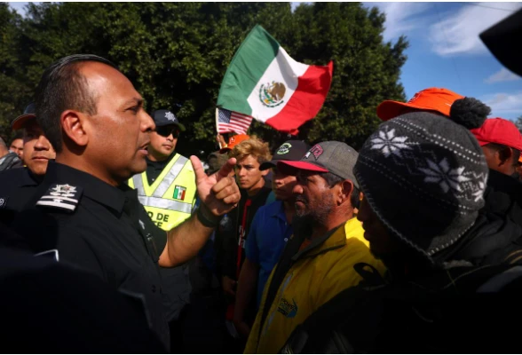 Người di cư Trung Mỹ va chạm với cảnh sát Mexico ở khu vực cửa khẩu El Chaparral, TP Tijuana (Mexico) giáp biên giới TP San Diago, bang California (Mỹ) ngày 22-11. Ảnh: REUTERS