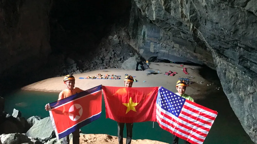 Một nhóm thám hiểm hang động Sơn Đoòng ở tỉnh Quảng Bình giơ cao các lá cờ Triều Tiên, Việt Nam, Mỹ (từ trái sang), chào mừng sự kiện cuộc gặp thượng đỉnh Mỹ-Triều sắp diễn ra tại Hà Nội vào ngày 27 và 28-2. Ảnh: AP