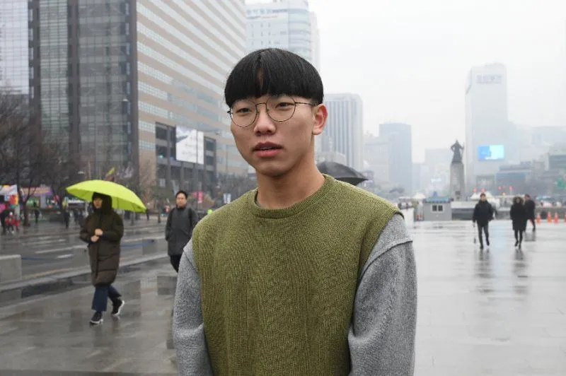 Anh Heo Jae-young 21 tuổi nói không thể quên cảnh Tổng thống Moon bắt tay Chủ tịch Kim và cùng bước qua đường phân giới quân sự. Ảnh: AFP