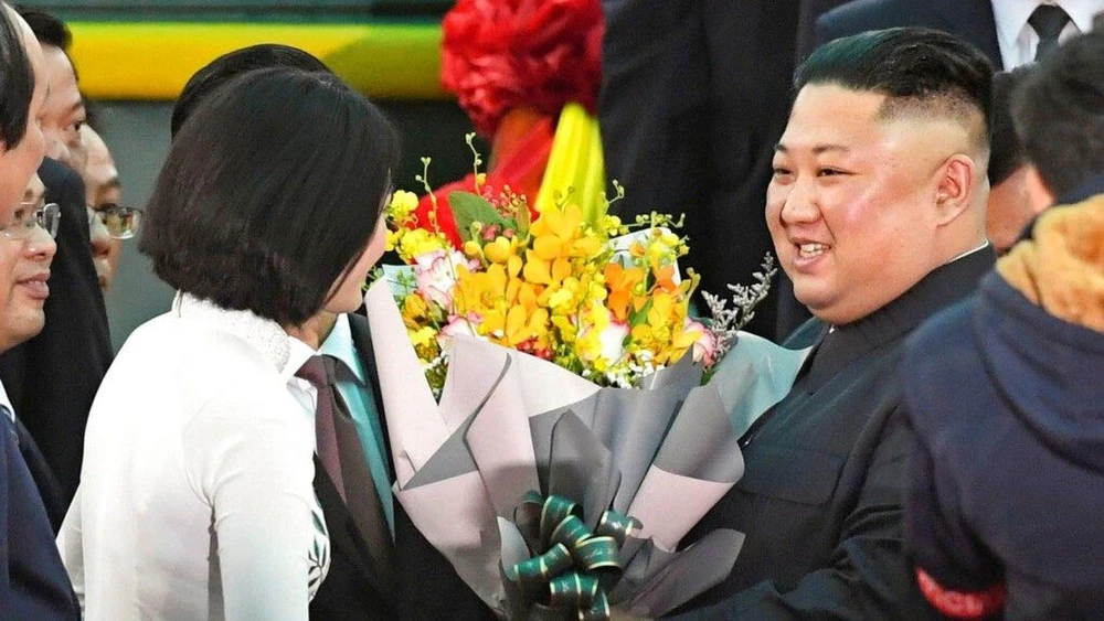 Lãnh đạo Triều Tiên Kim Jong-un (phải) được tặng hoa khi đến ga Đồng Đăng sáng qua. Ảnh: AP