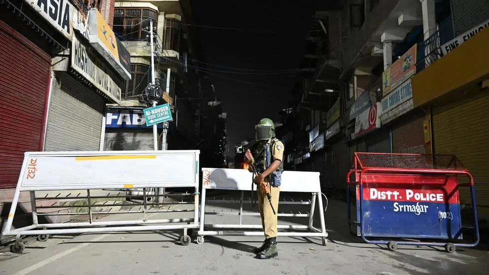 Lính thiết giáp bán quân sự Ấn Độ đứng canh gác tại một tuyến đường ở TP Srinagar thuộc bang Jammu and Kashmir, ngày 4-8. Ảnh: AFP
