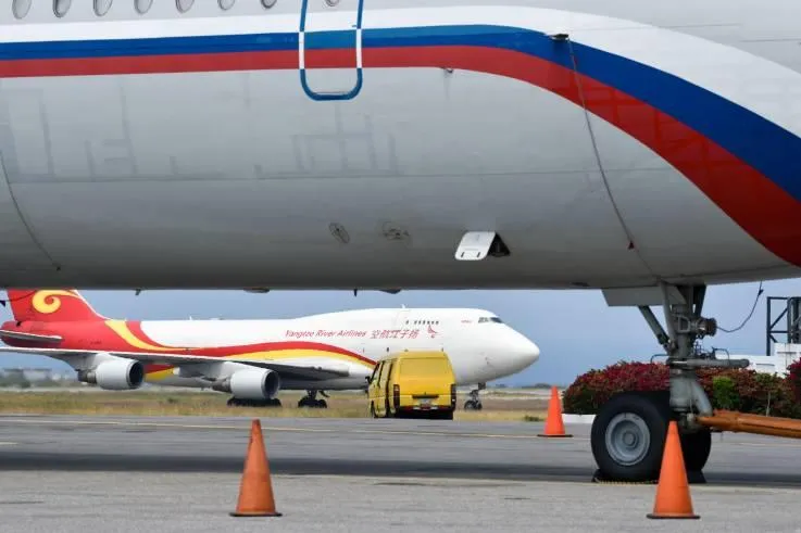 Máy bay Ilyushin Il-62M của không quân Nga và máy bay vận tải Boeing 747 của hãng hàng không vận tải Dương Tử Airlines của Trung Quốc tại sân bay quốc tế Simon Bolivar (Venezuela) ngày 29-3. Ảnh: AFP