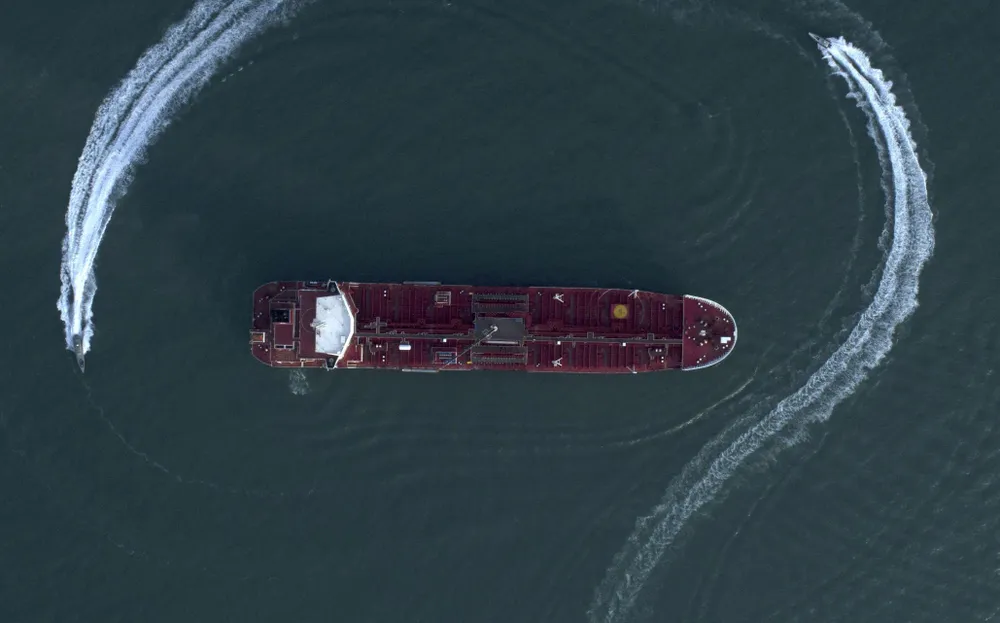 Hình ảnh chụp từ trên không ngày 21-7 cho thấy một xuồng máy của lực lượng Vệ binh Cách mạng Iran chạy quanh tàu dầu Stena Impero mang cờ Anh ở eo biển Hormuz. Tàu dầu này bị bắt về cảng Bandar Abbas của Iran. Ảnh: AP