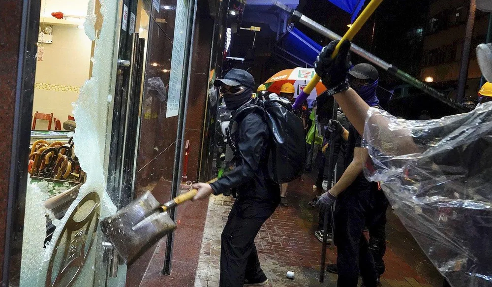 Người biểu tình đập phá một cửa hàng do người Trung Quốc đại lục mở ở Hong Kong, tối 25-8. Ảnh: AP