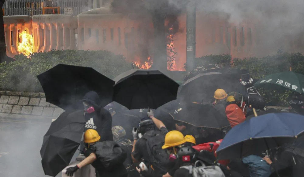 Người biểu tình phóng hỏa bên ngoài trụ sở chính quyền Hong Kong ngày 31-8. Ảnh: SCMP