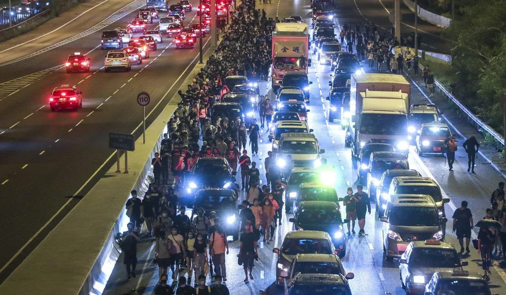 Người biểu tình đi bộ trên đường quốc lộ kéo về trung tâm TP tối 1-9. Ảnh: SCMP