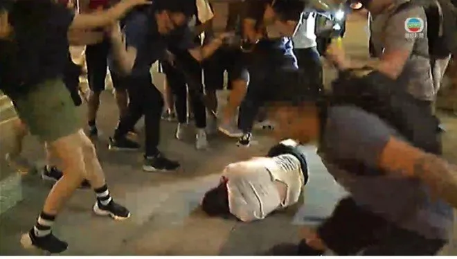 Một người đàn ông bị đánh nằm bất tỉnh trên đường với đầu đầy máu tối 15-9. Ảnh: SCMP