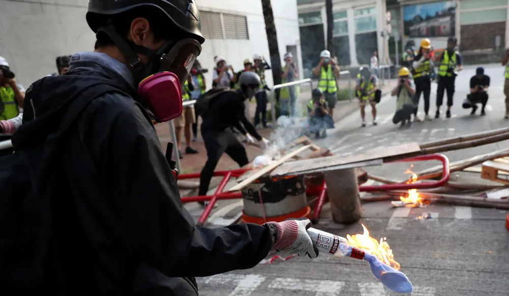 Người biểu tình chuẩn bị ném bom xăng khi xung đột với cảnh sát. Ảnh: SCMP