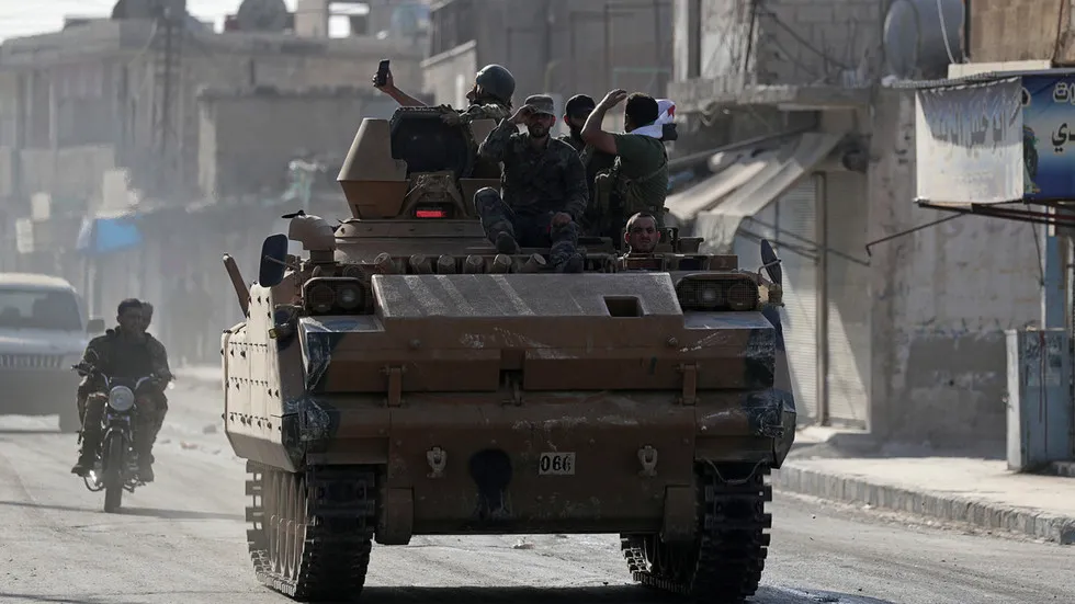 Lực lượng tay súng Syria được Thổ Nhĩ Kỳ bảo trợ di chuyển trên đường quốc lộ M4 qua thị trấn Tell Abyad, tỉnh Raqqa ở bắc Syria. Ảnh: REUTERS