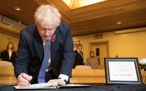 Thủ tướng Anh Boris Johnson viết vào sổ chia buồn với 39 nạn nhân chết trong thùng xe tải ở hạt Essex ngày 28-10. Ảnh: PA