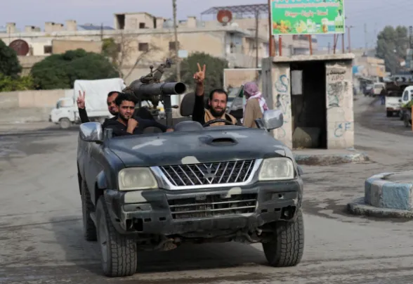 Các tay súng nổi dậy Syria (FSA) - được Thổ Nhĩ Kỳ bảo trợ và chiến đấu bên hàng ngũ Thổ Nhĩ Kỳ trong chiến dịch Mùa xuân Hòa bình - trên đường phố thị trấn Tal Abyad, tỉnh Raqqa (Syria) ngày 29-10. Ảnh: REUTERS