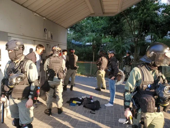 Cảnh sát chặn kiểm tra túi của hai thiếu niên trên đường phố Hong Kong sáng nay. Ảnh: SCMP