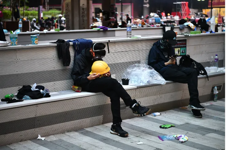 Người biểu tình (chủ yếu là sinh viên) ngủ trong mệt mỏi sau một ngày đêm xung đột với cảnh sát tại trường đại học Bách Khoa sáng 18-11. Một nữ sinh viên nói những người biểu tình bên trong trường đang thiếu thực phẩm và nước. Ảnh: GETTY IMAGES