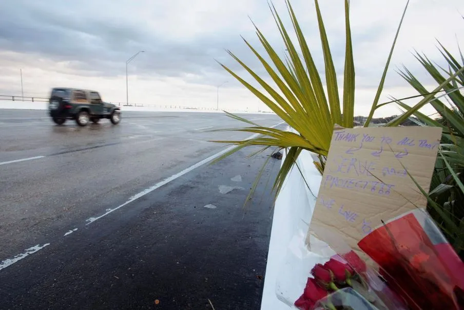 Thông điệp chia buồn được gắn tại cổng vào căn cứ hải quân Pensacola sau vụ xả súng sáng 6-12 làm 3 người chết 9 người bị thương. Ảnh: REUTERS