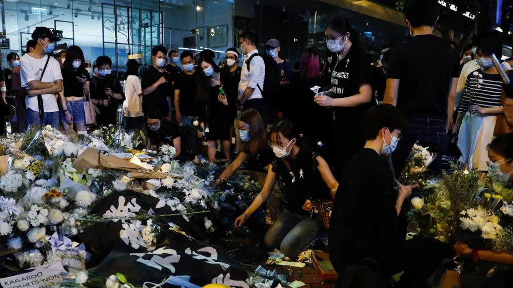 Hoa được đặt tại nơi người biểu tình Marco Leung Ling-kit rơi từ một giàn giáo xuống và chết trong cuộc biểu tình tại Hong Kong một năm trước, ngày 15-6. Ảnh: Tyrone Siu/REUTERS
