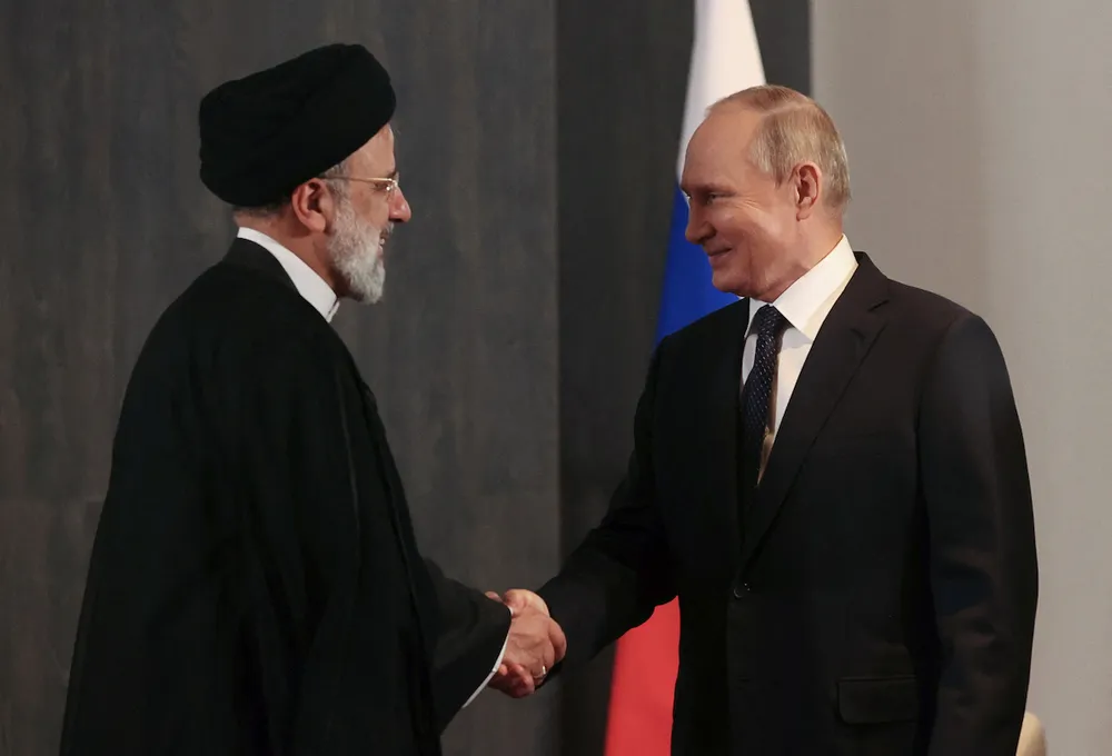 Tổng thống Nga Vladimir Putin (phải) bắt tay Tổng thống Iran Ebrahim Raisi trong cuộc gặp bên lề hội nghị thượng đỉnh Tổ chức Hợp tác Thượng Hải (SCO) ở Samarkand (Uzbekistan) ngày 15-9-2022. Ảnh: SPUNIK/ REUTERS