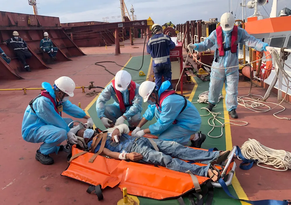 Lực lượng cứu hộ sơ cứu, đưa thủy thủ bị thương lên cán để đưa xuống tàu cứu nạn. Ảnh: NT.