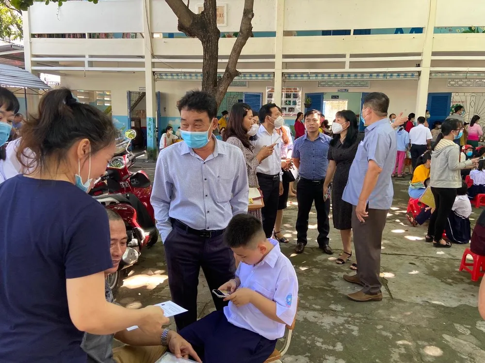 Nhân viên y tế tư vấn cho phụ huynh tiêm vaccine tại trường. Ảnh: TL