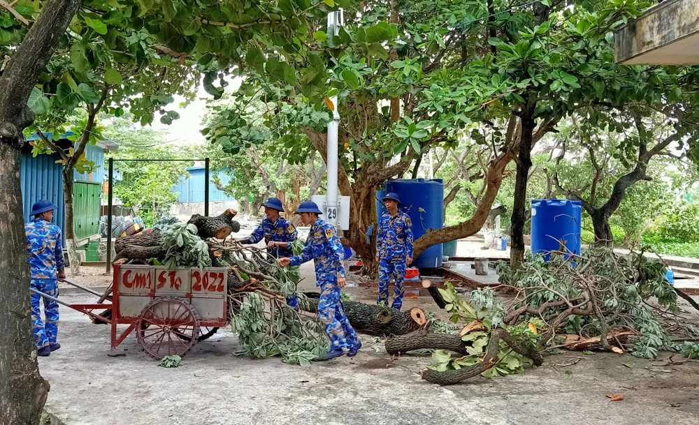 Các chiến sĩ cắt tỉa cành cây phòng chống bão số 4. Ảnh: NGUYỄN TOÀN.