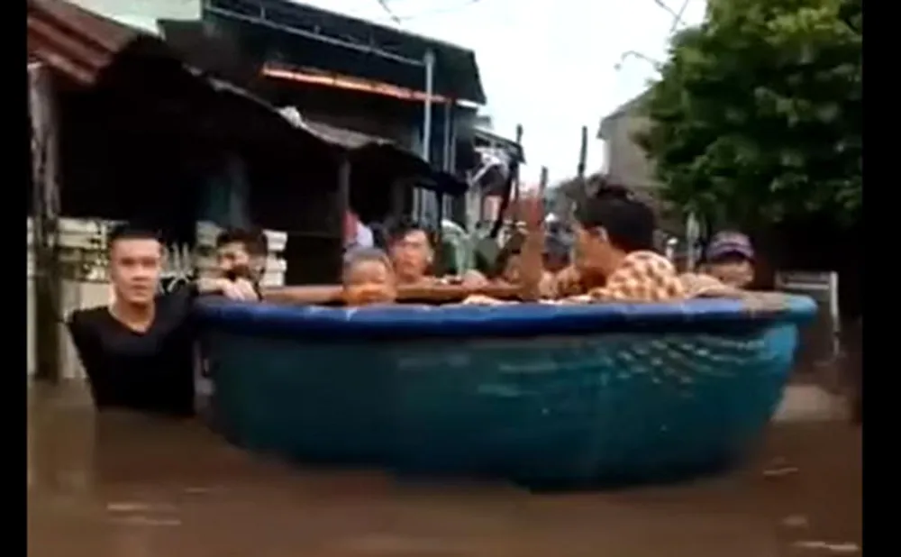 Người dân dùng thuyền thúng di chuyển những người già đến nơi an toàn. Ảnh: Cắt từ clip.