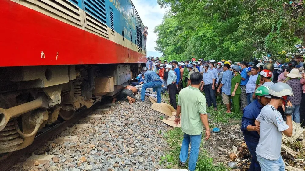 Lực lượng chức năng đưa thi thể nạn nhân bị mắc kẹt dưới đoàn tàu ra ngoài. Ảnh: NT. Lực lượng chức năng đưa thi thể nạn nhân bị mắc kẹt dưới đoàn tàu ra ngoài. Ảnh: NT.