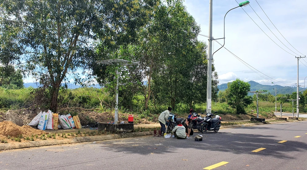 Vài công nhân được thuê trồng cỏ dọc các con đường trong cụm công nghiệp. Một công nhân cho hay mới được thuê hồi đầu tháng 11-2022.