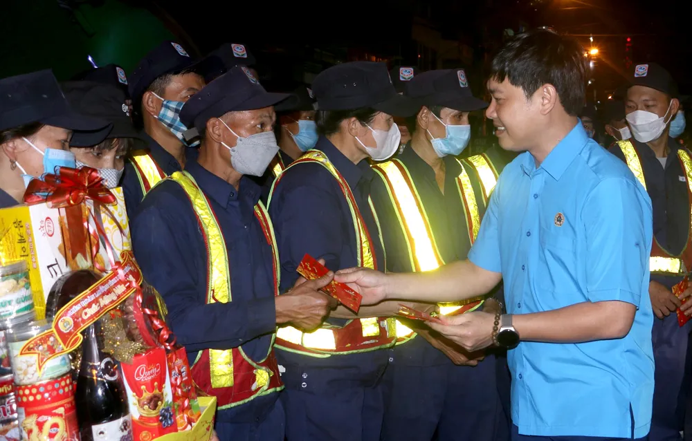 Ông Nam lì xì các công nhân vệ sinh tại chợ Xóm Mới. Ảnh: VÂN TRẦN.