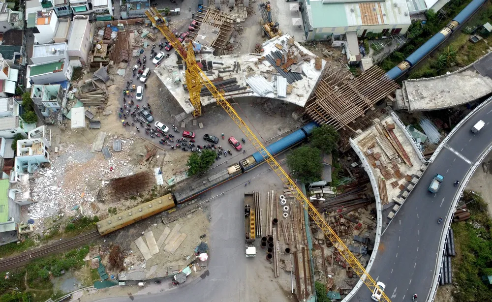 Theo ghi nhận của PV sáng 14-3, chủ đầu tư vẫn chưa có biện pháp bảo đảm an toàn cho người đi đường mà vẫn tiến hành thi công bình thường. Giờ cao điểm hoặc những lúc đoàn tàu lửa đi qua, dòng xe cộ vẫn len lỏi chen nhau đi dưới cần cẩu khổng lồ và những thanh sắt lớn.