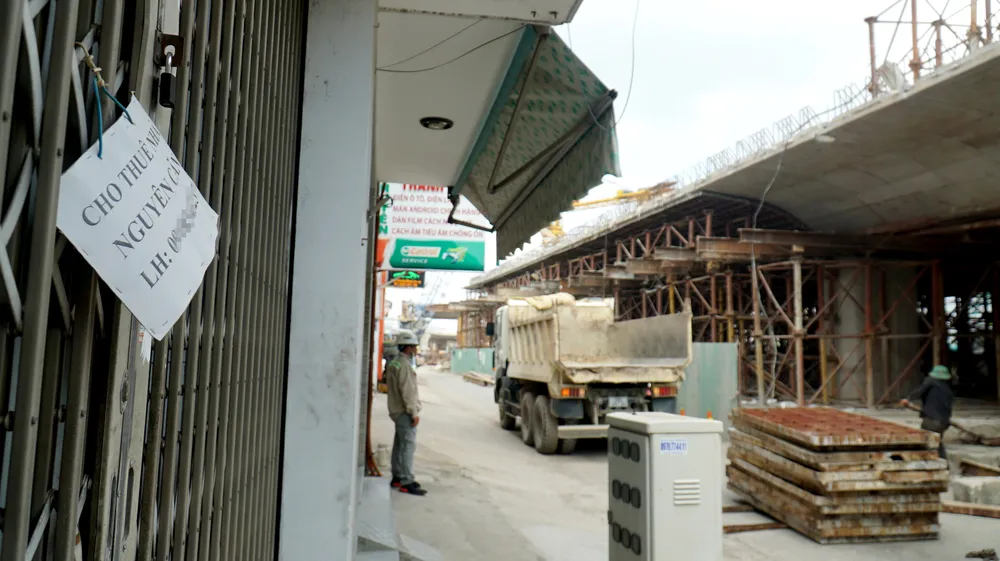 Người dân cho biết những do nằm cạnh công trình nên buôn bán ế ẩm. Những mặt bằng trước đây là &quot;mặt tiền vàng&quot; giờ treo bảng không ai thuê. &quot;Dự án giao thông quốc gia nên chúng tôi vẫn chịu thiệt thòi để họ thi công. Tuy nhiên, chúng tôi mong công trình nhanh chóng hoàn thành để ổn định cuộc sống&quot;- một người dân nói.