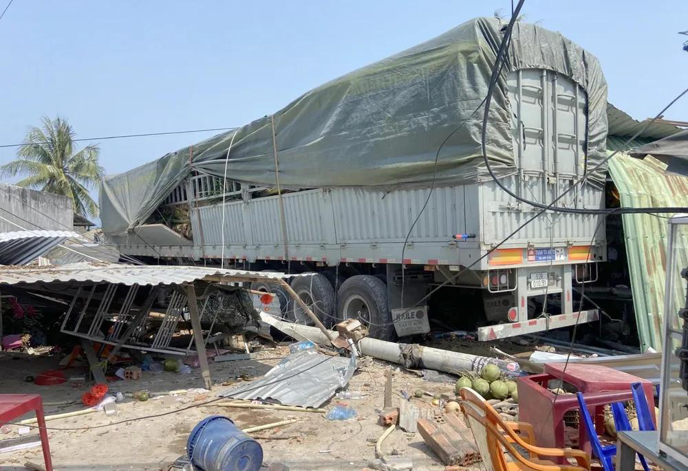 Chiếc xe tải chở dừa tông sập nhà dân sau khi tránh các ống thép rơi xuống đường. Ảnh: T.Q