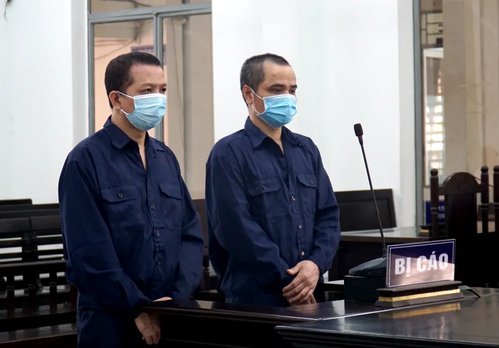 Bị cáo Nguyễn Chí Uy (phải) và Đào Trung Dũng tại phiên tòa sáng 18-4. Ảnh: H.H