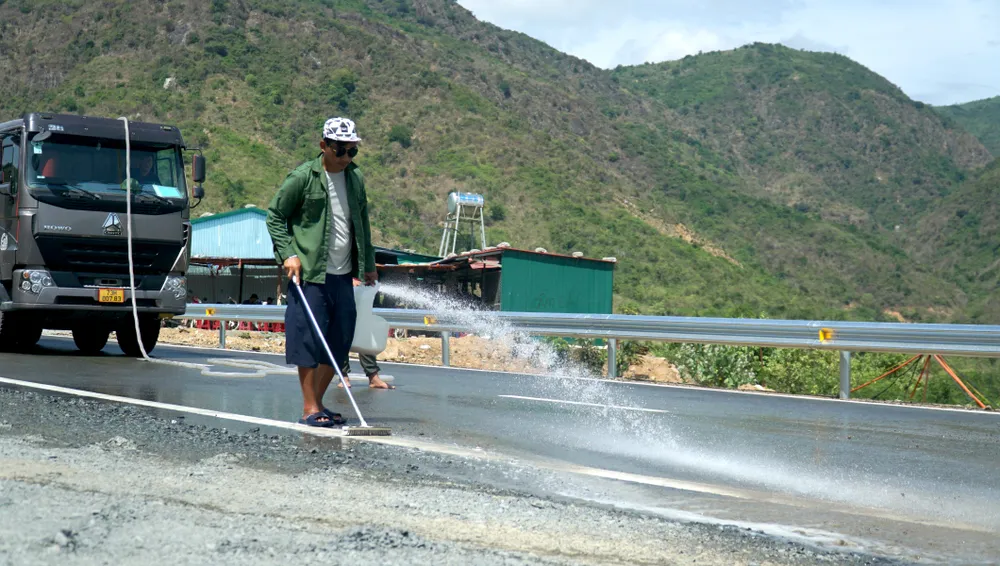 Các công nhân đang dọn dẹp, vệ sinh mặt đường tại những đoạn đã hoàn thành thành.