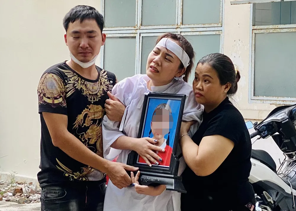 Mẹ hai bé gái khóc ngất bên di ảnh của con. Ảnh: CHU VÂN Mẹ hai bé gái khóc ngất bên di ảnh của con. Ảnh: CHU VÂN