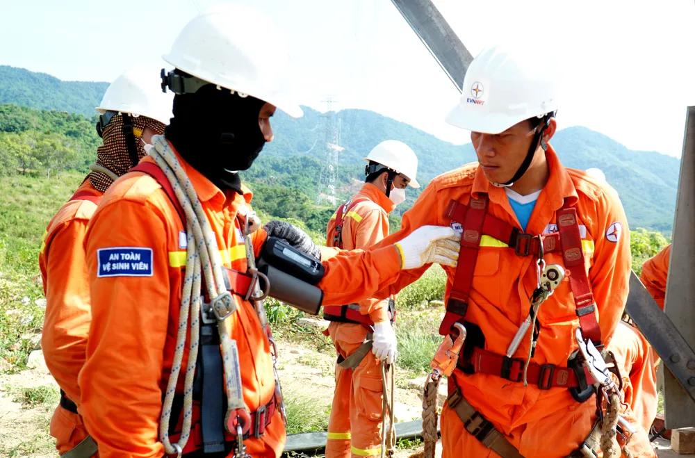 Các cán bộ kỹ thuật được kiểm tra sức khỏe, đo huyết áp trước khi leo lên trụ điện 500 kV. Ảnh: H.H