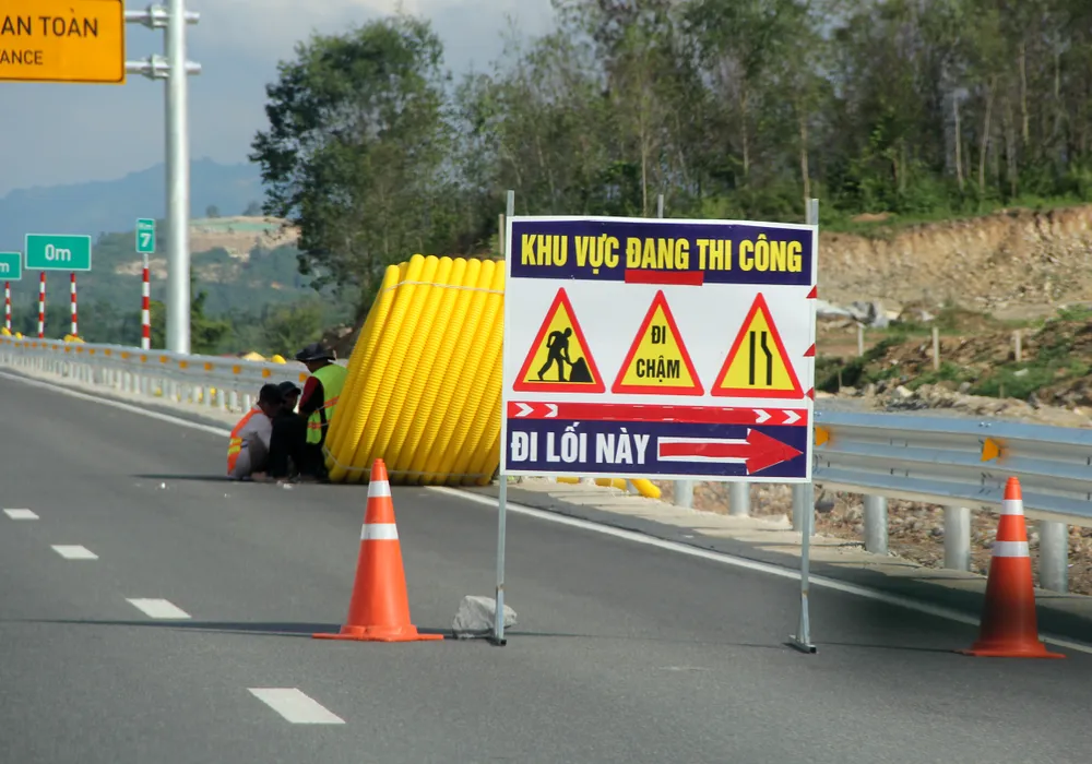 Một số khác đang thi công đường dây điện để lắp đặt camera giám sát hành trình. Họ tụm lại ngồi trong các cuộn dây điện trên cao tốc để tránh nắng.