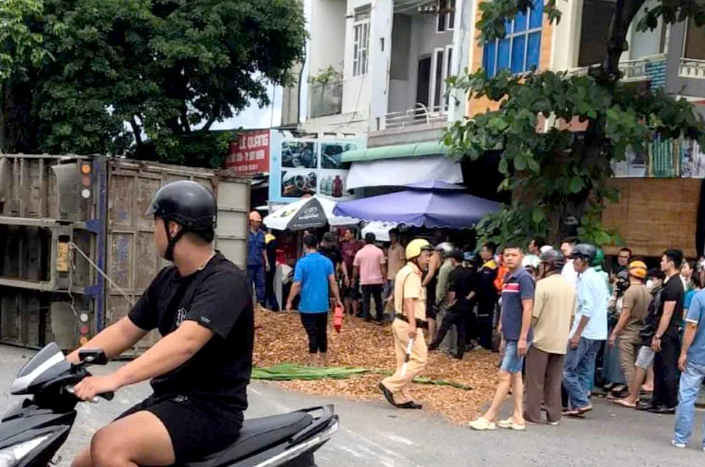 Lượng dăm gỗ đổ xuống đường nhiều khiến công tác cứu hộ gặp khó khăn. Ảnh: M.T xe chở dăm gỗ lật.jpg