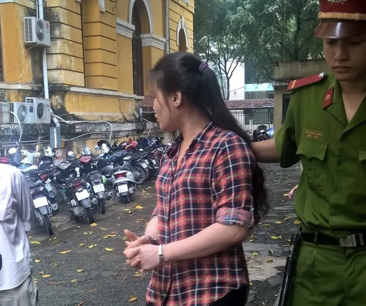 Mẫn quay lại trấn an người thân trước khi theo cán bộ dẫn giải về trại giam