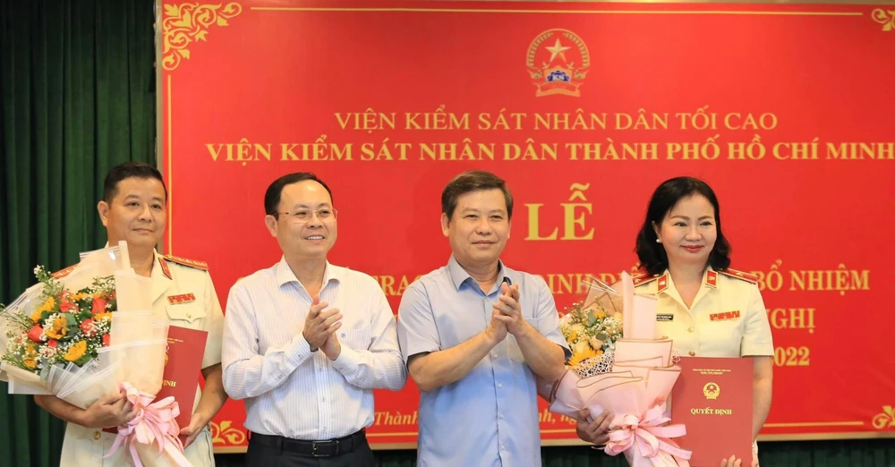 Viện trưởng VKSND Tối cao Lê Minh Trí và Phó bí thư Thành uỷ TP.HCM Nguyễn Văn Hiếu trao quyết định và tặng hoa cho hai tân phó viện trưởng. Ảnh: H.Y