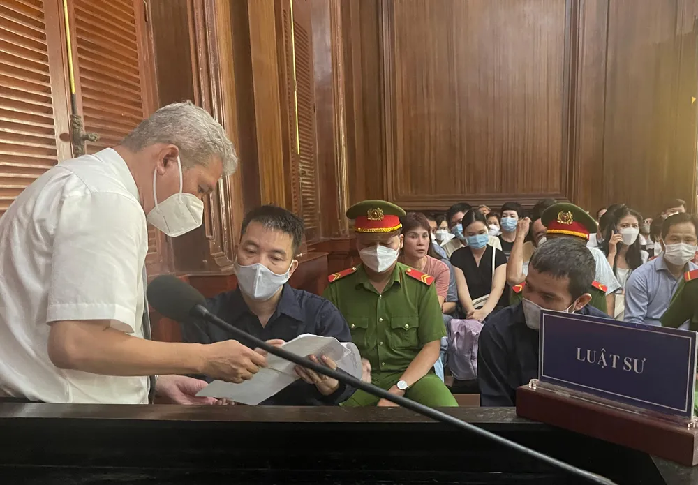 Bị cáo trao đổi với luật sư trước khi khai mạc phiên xử. Ảnh: H.YẾN