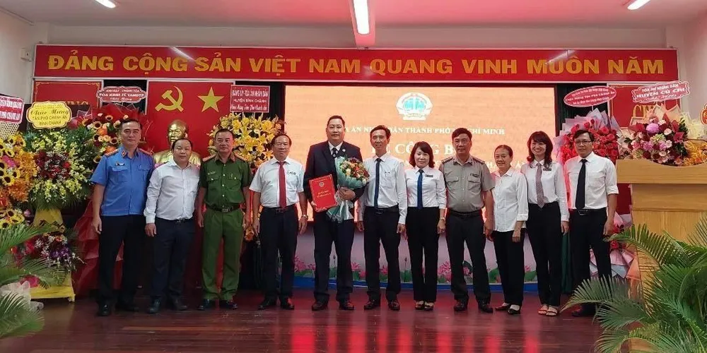 Lãnh đạo các đơn vị chụp hình chúc mừng tân phó chánh án TAND huyện Bình Chánh. Ảnh: H.YẾN