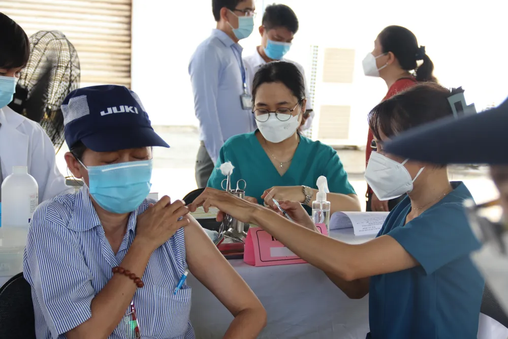 Công nhân Công ty Juki Việt Nam tiêm vaccine mũi 3, mũi 4 sáng 14-6. Ảnh: HL