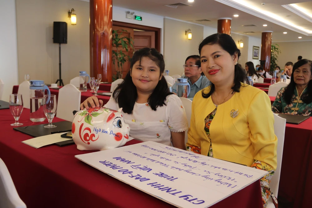 Bé Ngô Kim Duyên, học sinh lớp 3 trường tiểu học Trần Quang Vinh (quận Bình Thạnh) cùng mẹ đến ủng hộ chương trình. Ảnh: HOÀNG LAN