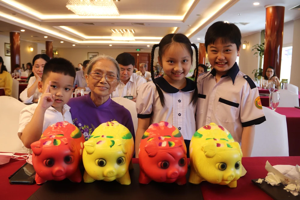 Bà Nguyễn Thị Mai Lan, TP Thủ Đức đưa các cháu đến ủng hộ heo đất cho biển đảo, riêng bà Lan ủng hộ xây một căn nhà đồng đội 80 triệu và 20 suất học bổng. Ảnh: HOÀNG LAN