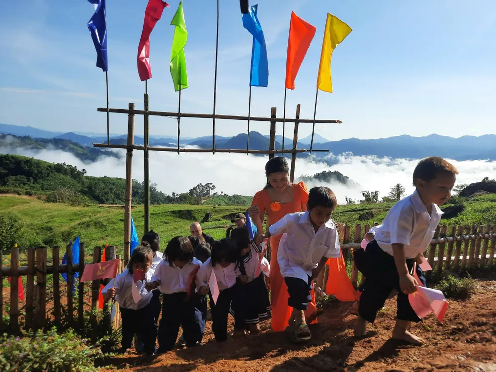 Học sinh đến dự lễ khai giảng ở điểm trường Tăk Pổ, trường Phổ thông dân tộc bán trú tiểu học Trà Tập (xã Trà Tập). Mây trắng vây quanh điểm trường. Ảnh: Cô Thu